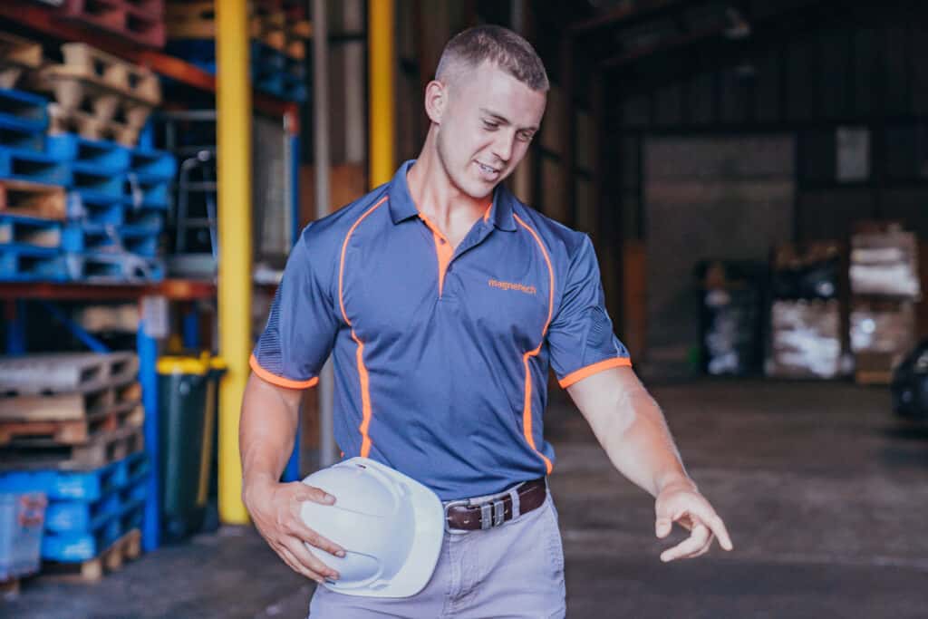 Magnetech technician holding a hat points to the floor